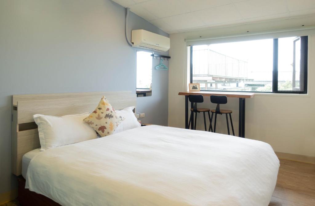 a bedroom with a large white bed and a window at Cen Pin B&B in Jiufen