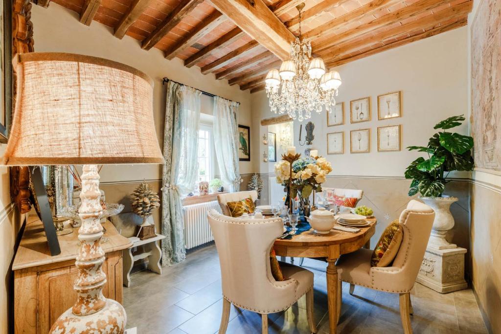 une salle à manger avec une table, des chaises et un lustre dans l'établissement Villa Gianna, the Secret Interior Designer's Private Retreat with Pool, à San Piero in Campo