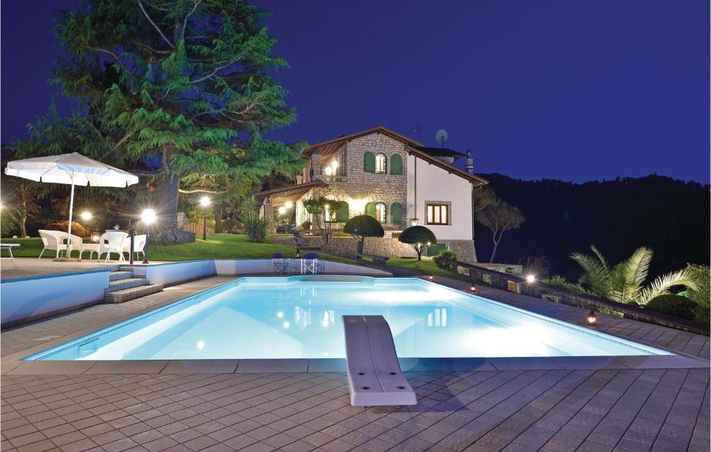 - une piscine en face d'une maison la nuit dans l'établissement Amazing Home In Camaiore lu With Wifi, à Camaiore
