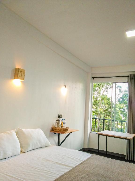 a bedroom with a bed and a window at Crystal Resort in Badulla