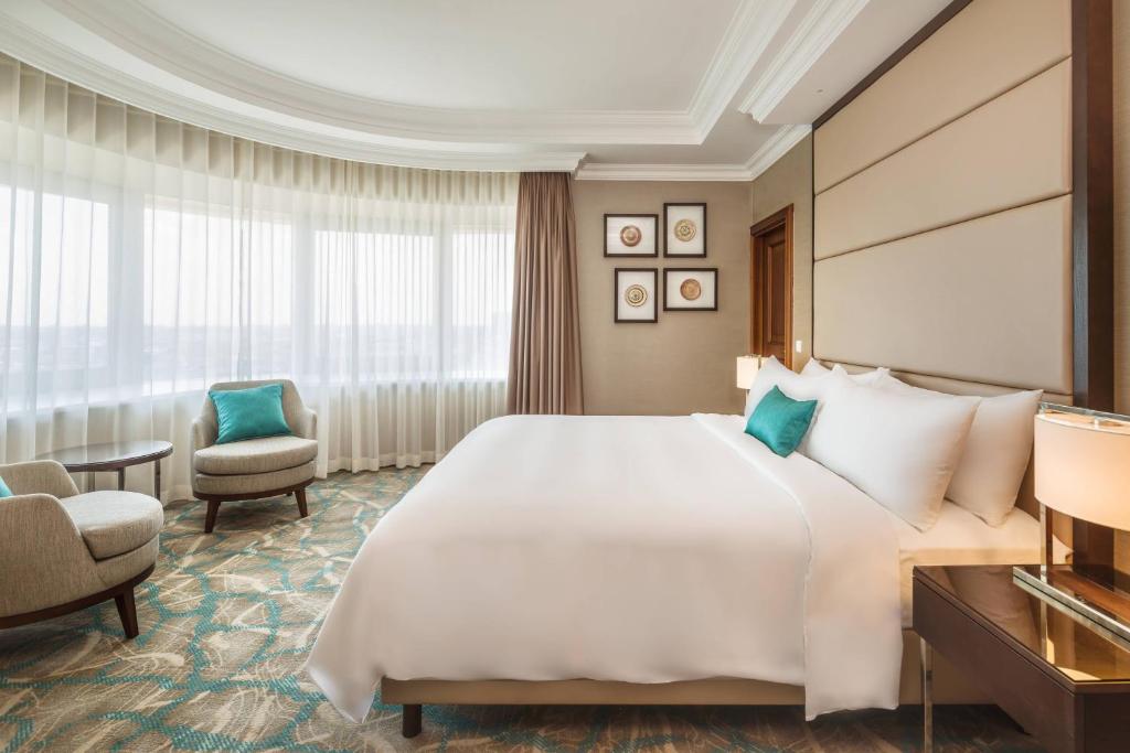 Un pat sau paturi într-o cameră la JW Marriott Bucharest Grand Hotel