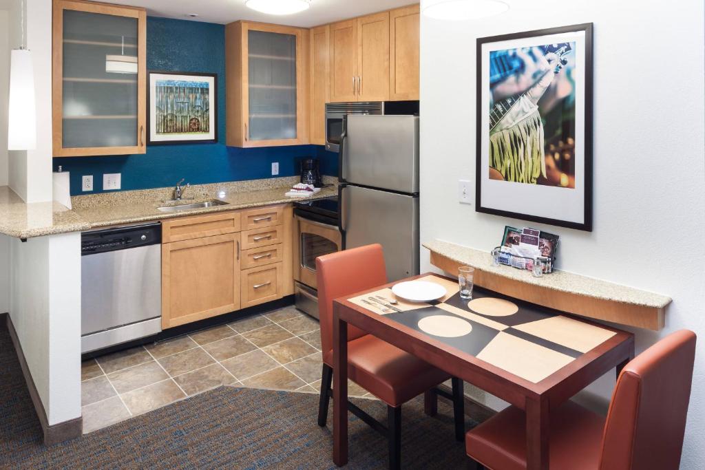 eine Küche mit einem Tisch und einem Kühlschrank sowie einem Tisch und Stühlen in der Unterkunft Residence Inn by Marriott Franklin Cool Springs in Franklin
