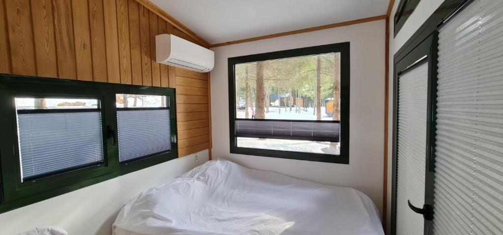 een kleine kamer met een bed en 2 ramen bij Tumba Sisli Vadi in Kartepe