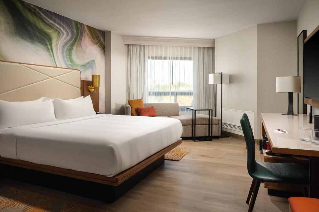 フォート・コリンズにあるFort Collins Marriottのベッドとデスクが備わるホテルルームです。