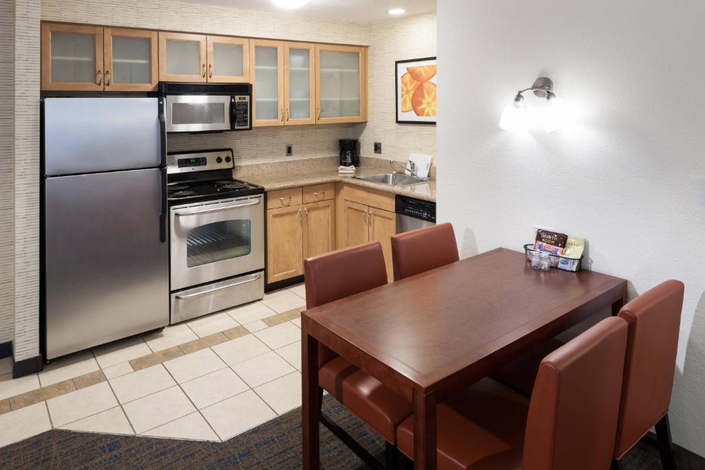 a kitchen with a wooden table and stainless steel appliances at Residence Inn Boston Marlborough in Marlborough