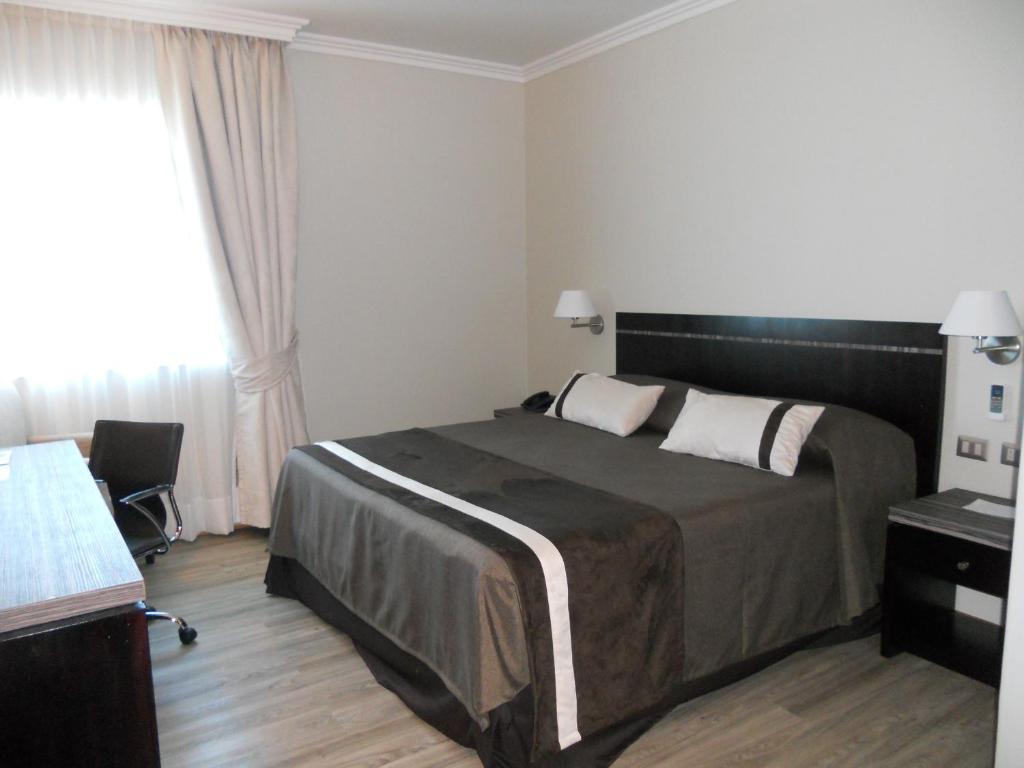 Una cama o camas en una habitación de Hotel Diego de Almagro Chillan