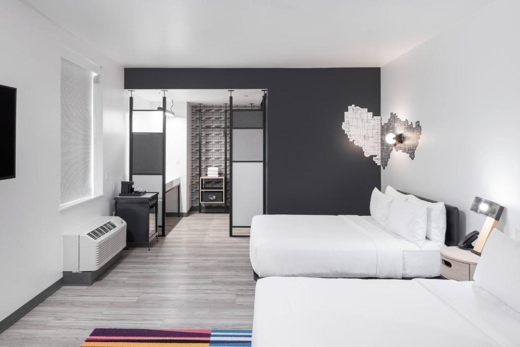 a hotel room with two beds and a bathroom at Aloft Oklahoma City Quail Springs in Oklahoma City