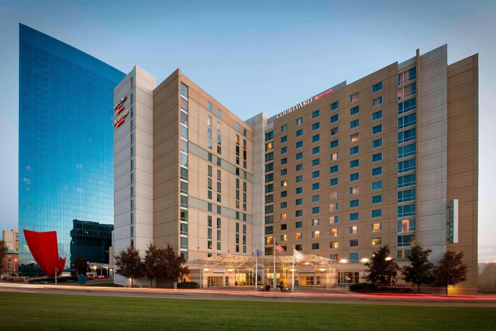 a large hotel building with a field in front of it at Courtyard Indianapolis Downtown in Indianapolis