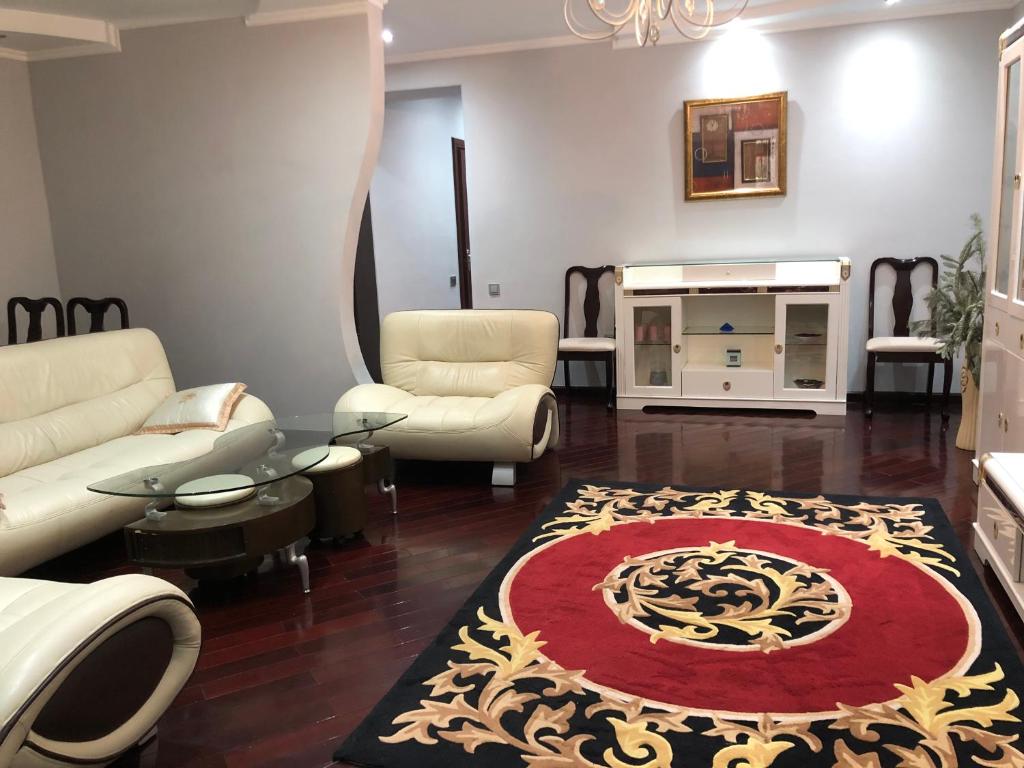 een woonkamer met een bank en een tapijt bij Beautiful apartments in the heart of the city in Tasjkent