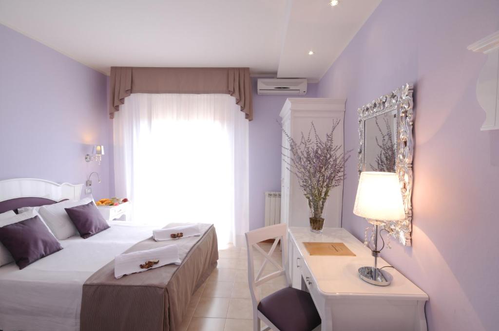 sypialnia z łóżkiem i stołem z lampką w obiekcie Hotel I Due Cigni w mieście Montepulciano