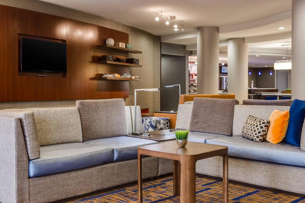 a living room with two couches and a tv at Courtyard Des Moines Ankeny in Ankeny