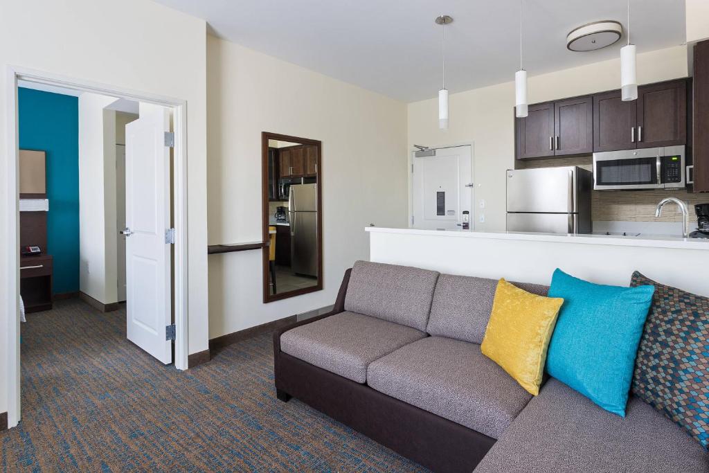 Residence Inn by Marriott Houston West/Beltway 8 at Clay Road في هيوستن: غرفة معيشة مع أريكة ومطبخ
