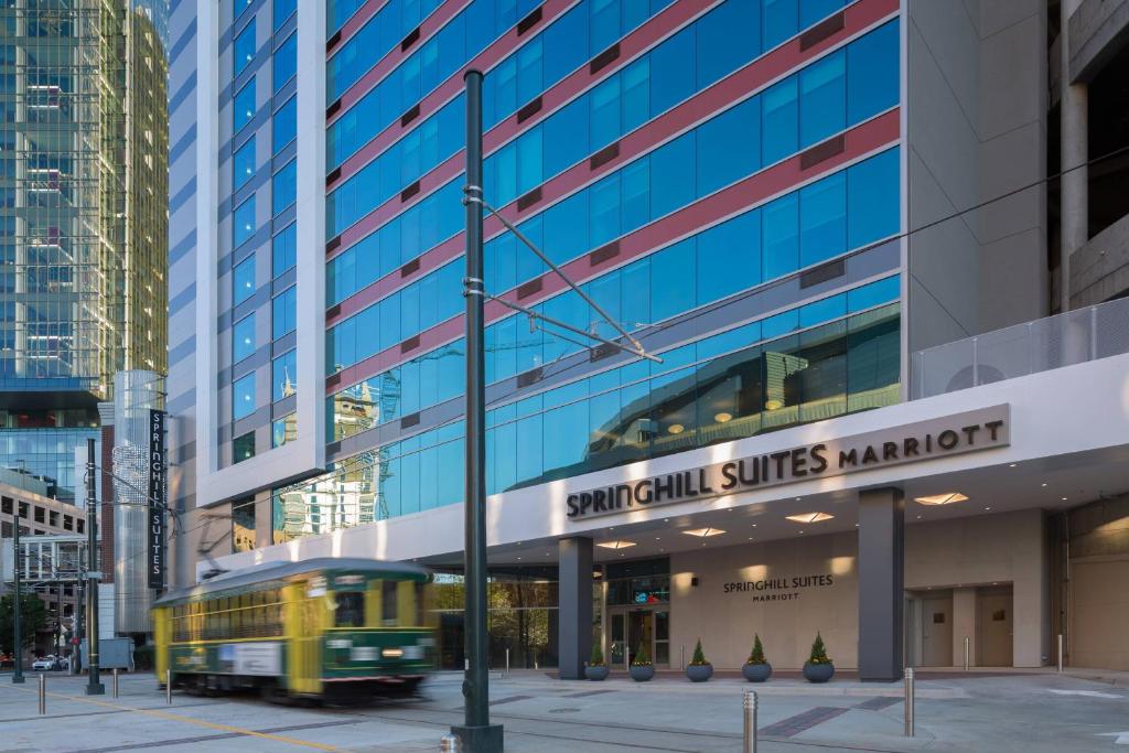 un autobús amarillo conduciendo delante de un edificio en SpringHill Suites by Marriott Charlotte City Center, en Charlotte