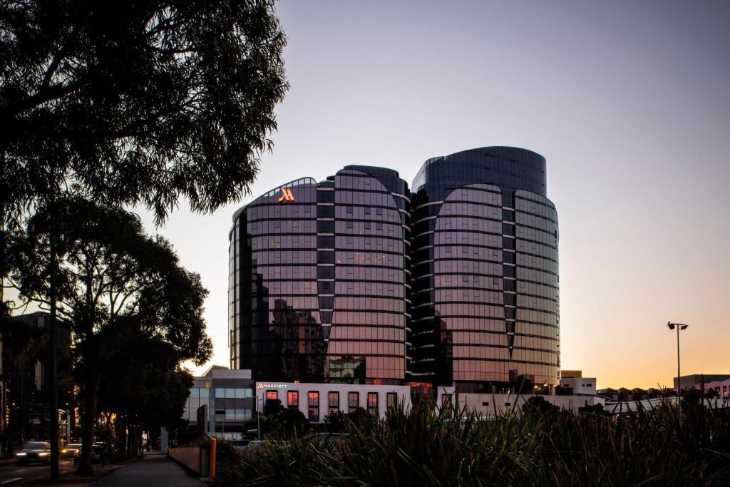 two tall buildings in a city at sunset at Melbourne Marriott Hotel Docklands in Melbourne