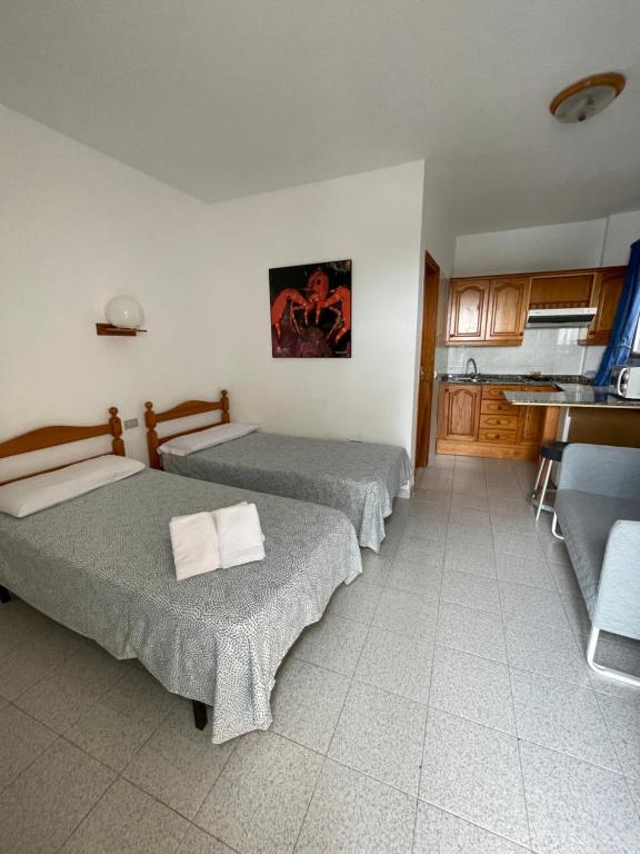 Habitación con 2 camas y cocina con cocina. en ROCAMAR en La Restinga