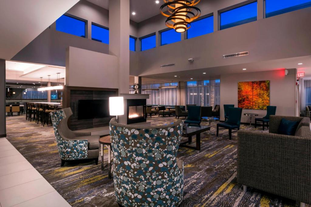 a hotel lobby with a fireplace and tables and chairs at Residence Inn by Marriott Fishkill in Fishkill