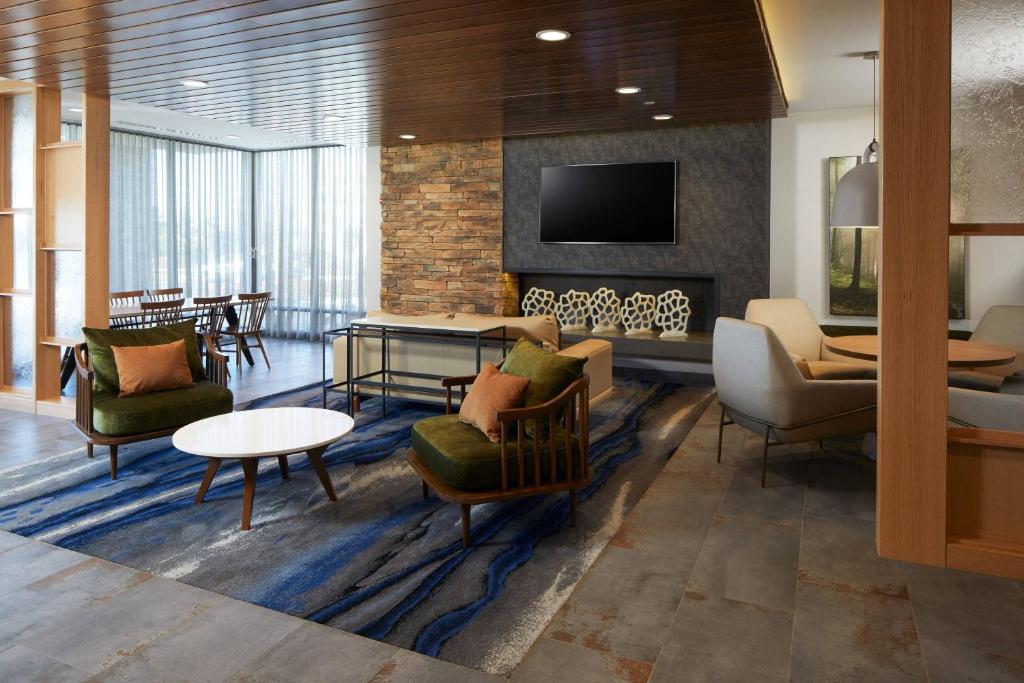莫雷諾谷的住宿－Fairfield Inn & Suites by Marriott Riverside Moreno Valley，大堂设有椅子、壁炉和桌子。