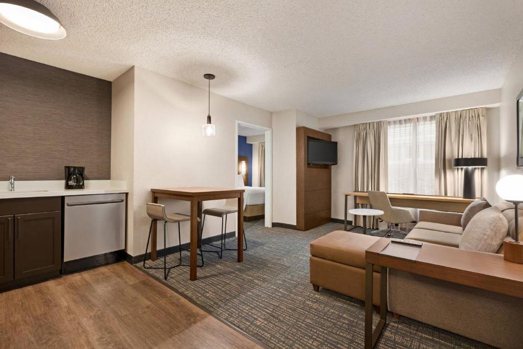 a living room with a couch and a table in a hotel room at Residence Inn by Marriott Norfolk Airport in Norfolk