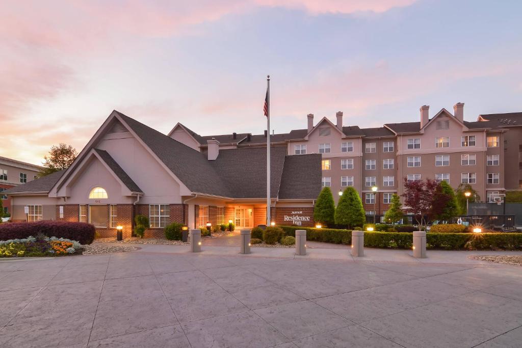 a hotel with a flag in front of a building at Residence Inn by Marriott Charlotte Piper Glen in Charlotte