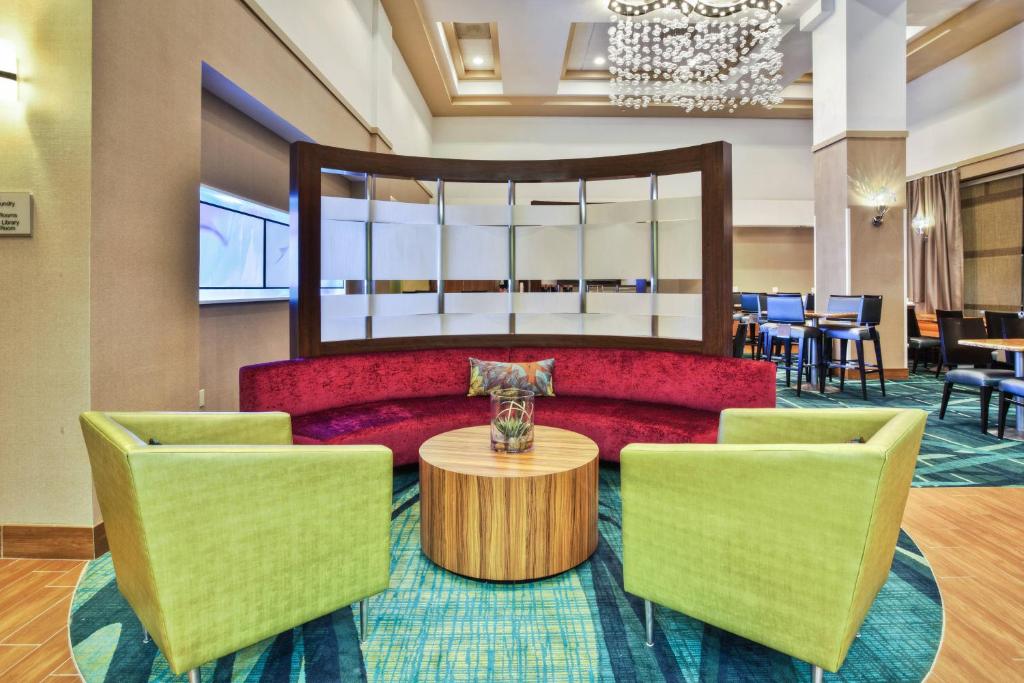 a lobby with a red couch and two chairs at SpringHill Suites Chicago Elmhurst/Oakbrook Area in Elmhurst