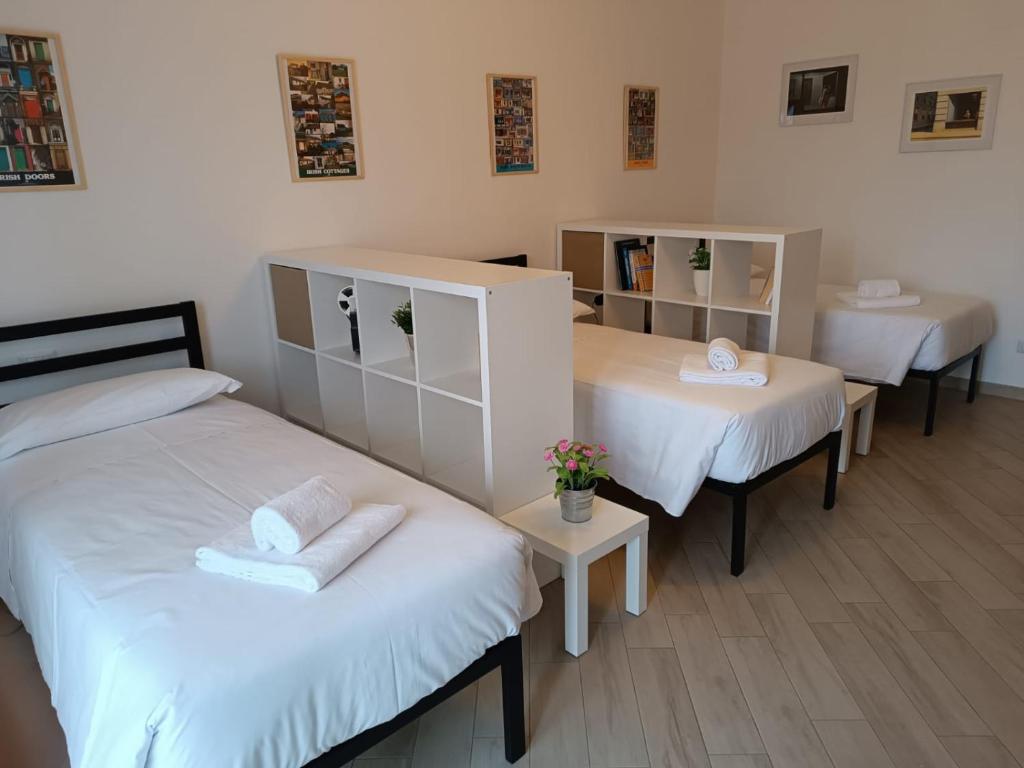 une chambre avec deux lits et deux tables dans l'établissement Bnbook Residenza Lo Scoiattolo, à Rho