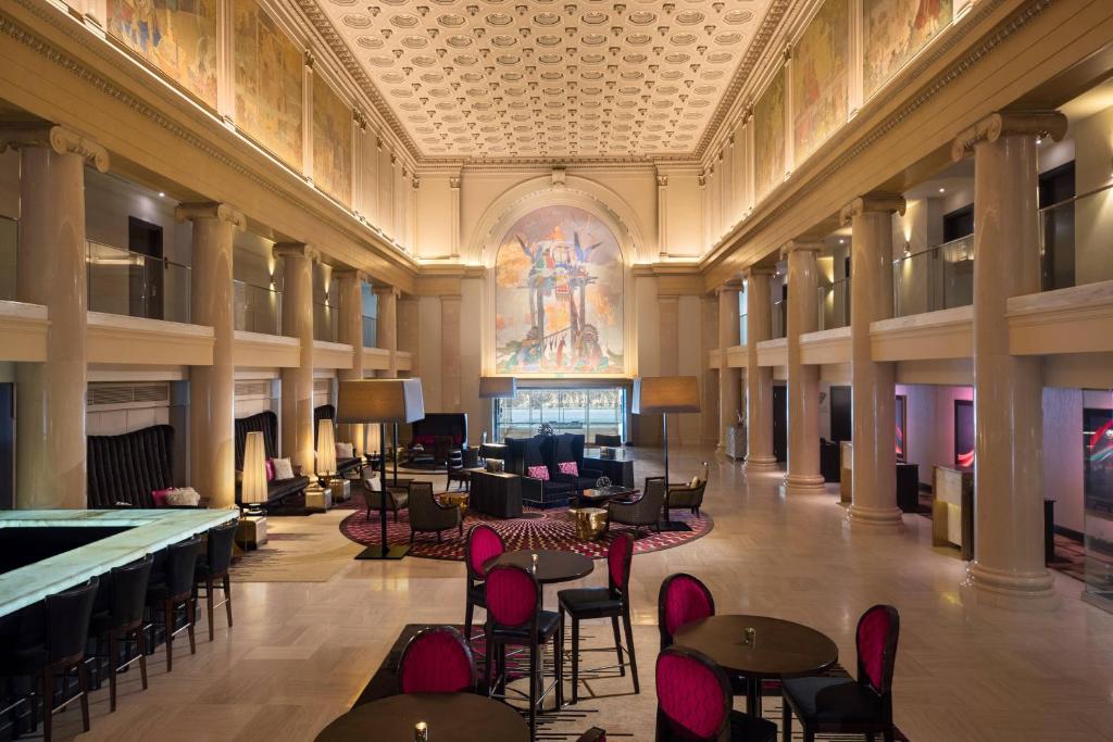 een lobby met tafels en stoelen en een schilderij aan het plafond bij Renaissance Denver Downtown City Center Hotel in Denver