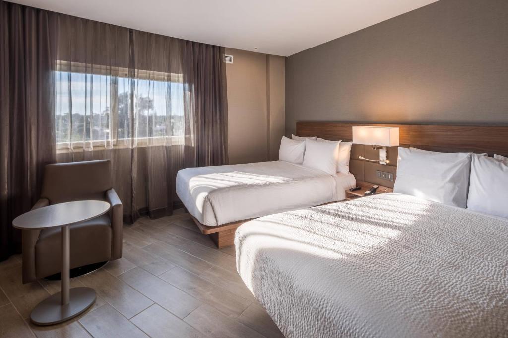 um quarto de hotel com duas camas e uma janela em AC Hotel by Marriott Guadalajara Expo em Guadalajara