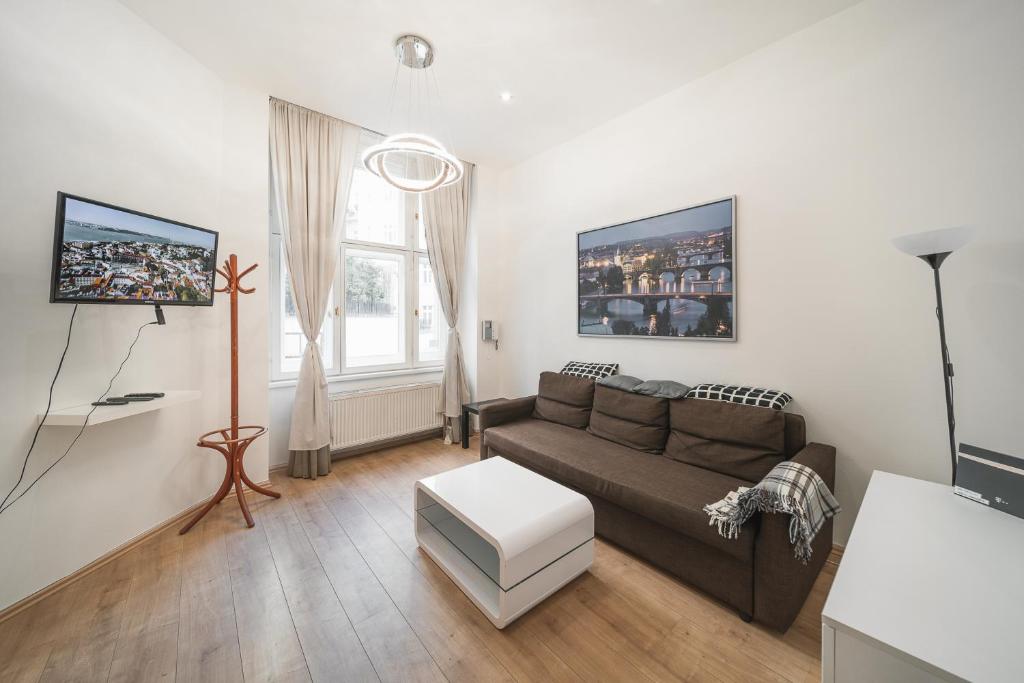uma sala de estar com um sofá e uma mesa em Josefov Riverside Apartment em Praga