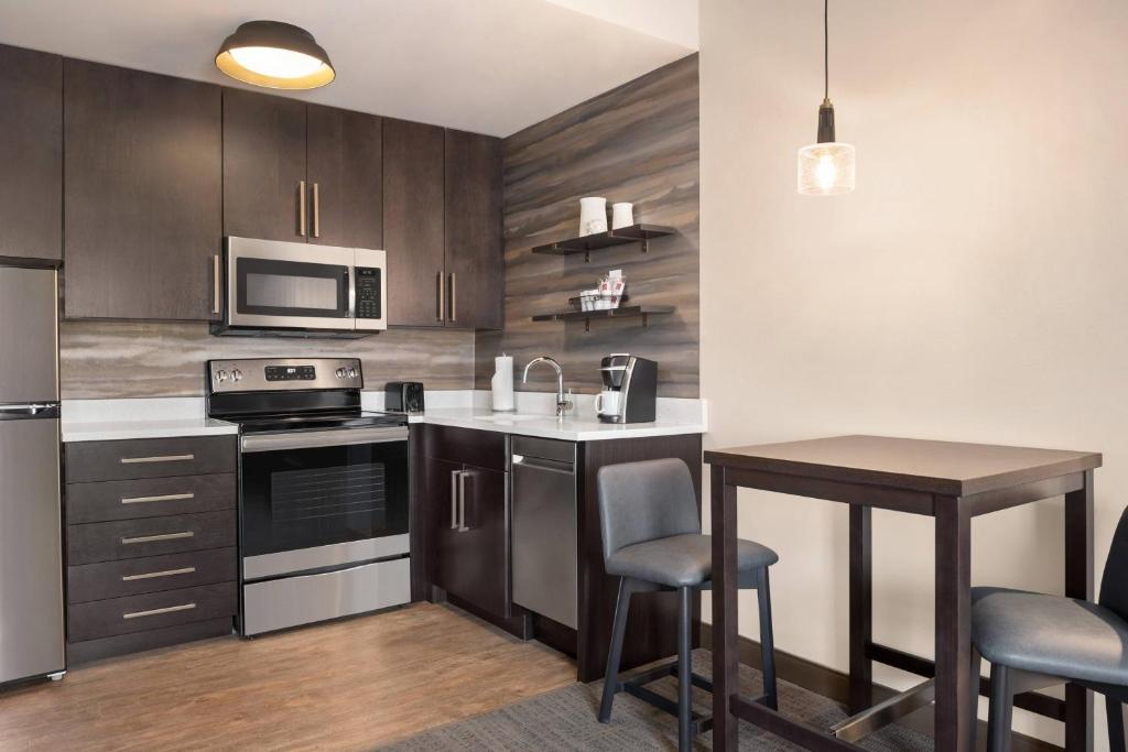 安克尼的住宿－Residence Inn by Marriott Des Moines Ankeny，厨房配有木制橱柜和桌椅