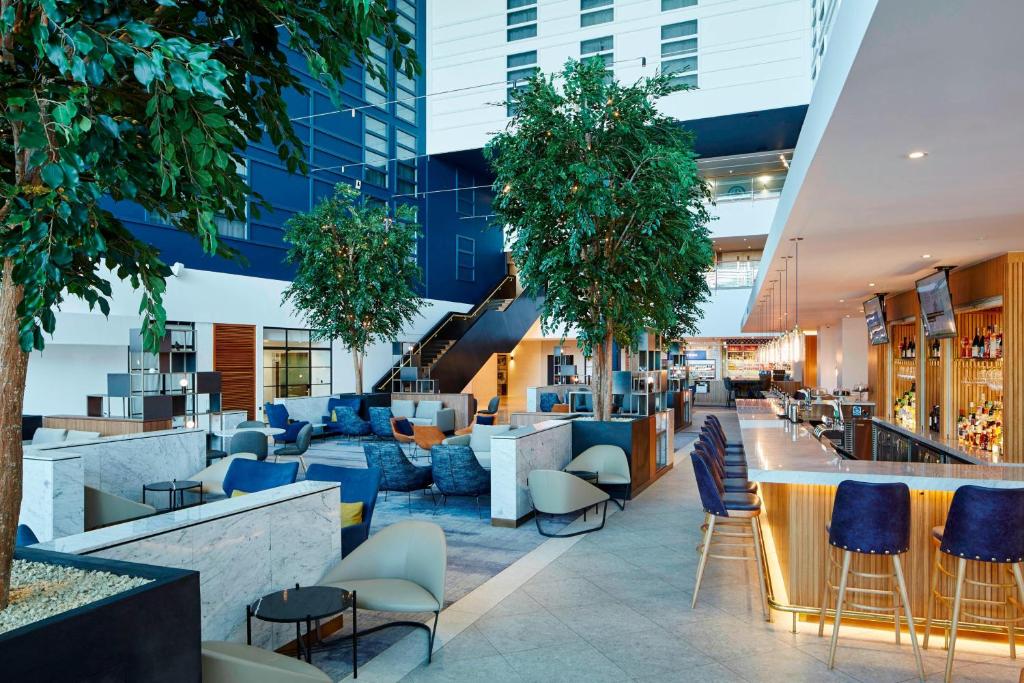 un hall de bureau avec un bar et des chaises dans l'établissement London Heathrow Marriott Hotel, à Hillingdon