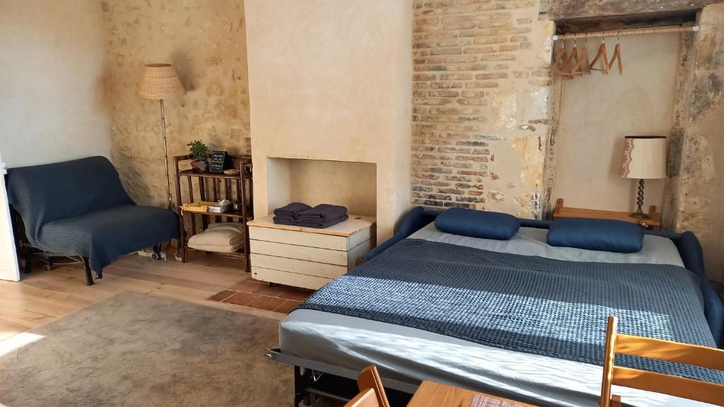 - une chambre avec un lit et une chaise dans l'établissement Au bois radieux - option massage, à Bellême