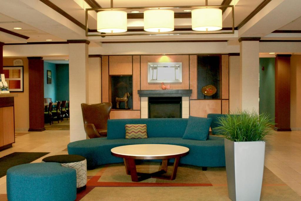 Una sala de estar con un sofá azul y una mesa. en Fairfield Inn &amp; Suites by Marriott Fairmont, en Fairmont
