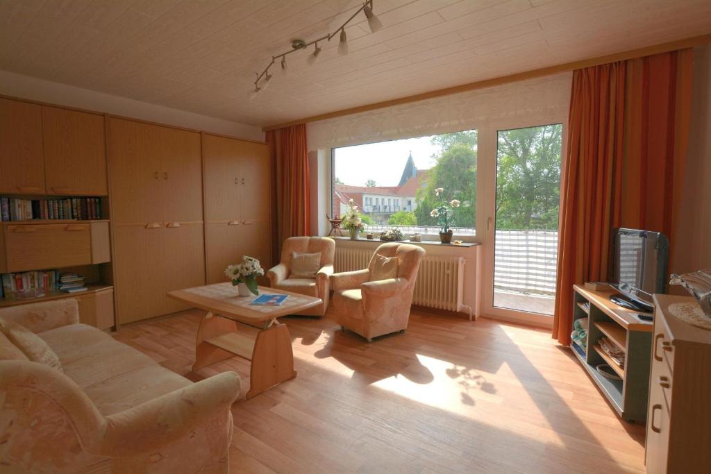 ein Wohnzimmer mit einem Sofa, Stühlen und einem TV in der Unterkunft Haus Bünzow 1 in Borkum
