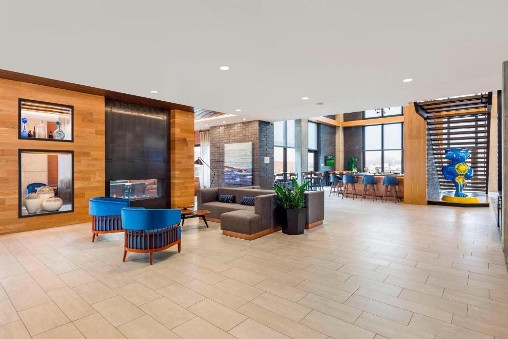 a lobby with a couch and tables and chairs at SpringHill Suites Madison in Madison