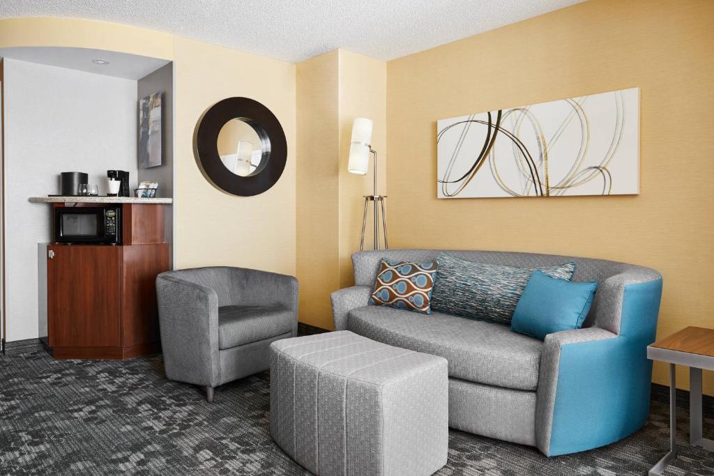 uma sala de estar com um sofá e uma cadeira em Courtyard by Marriott Newark Downtown em Newark