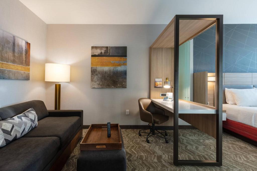 um quarto de hotel com um sofá, uma secretária e uma cama em SpringHill Suites by Marriott Chattanooga South/Ringgold em Ringgold