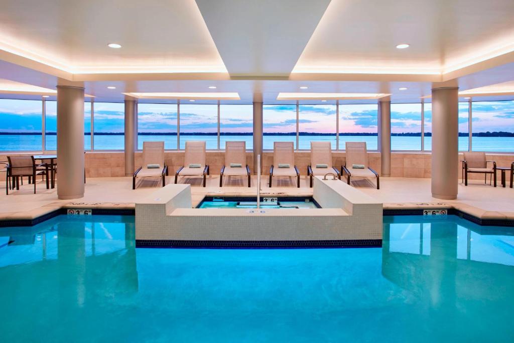 a pool in a hotel with chairs and tables at Courtyard by Marriott Erie Bayfront in Erie