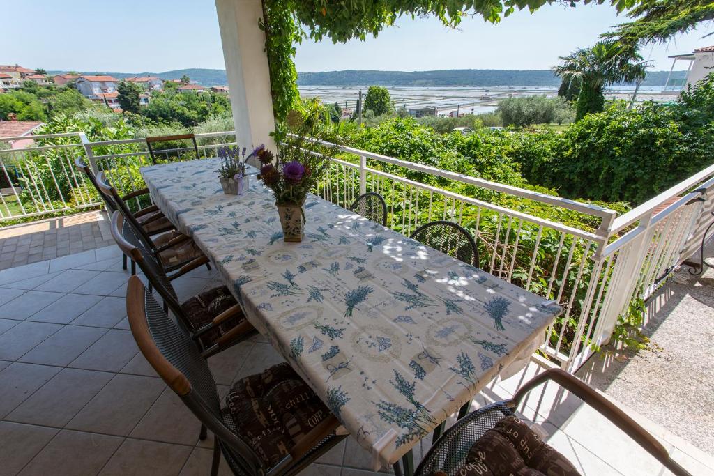 una mesa con un jarrón de flores en el balcón en Vista del Sal en Portorož