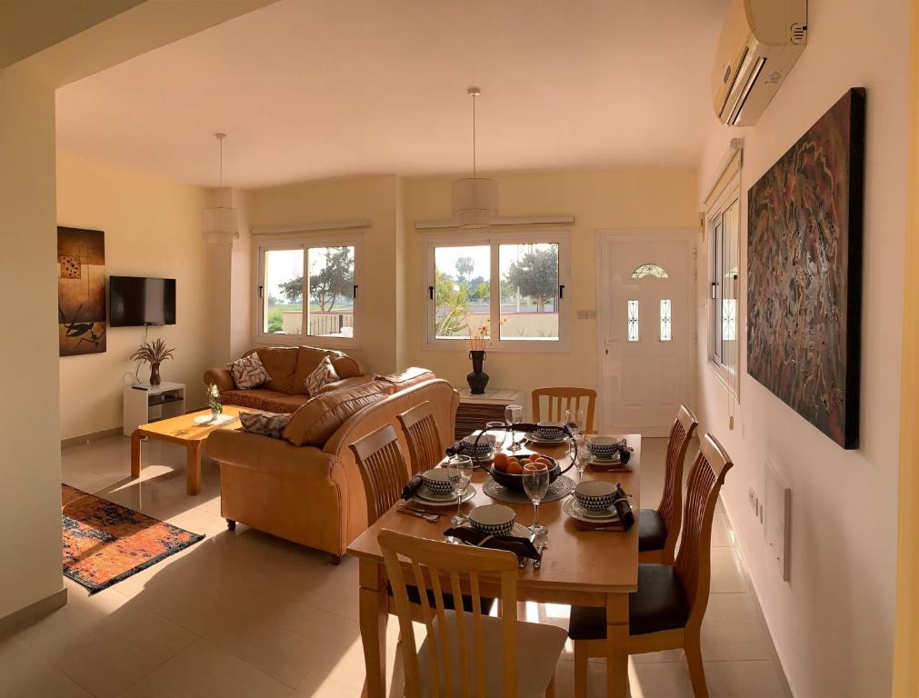 een woonkamer met een tafel en een bank bij Sunrise Villa 11 in Ayia Thekla in Ayia Napa