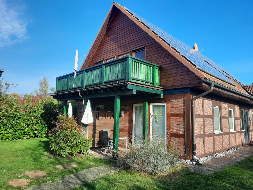 uma casa com uma varanda em cima em Ferienhaus Sasse Ferienwohnungen mit Garten & Grill em Mölschow