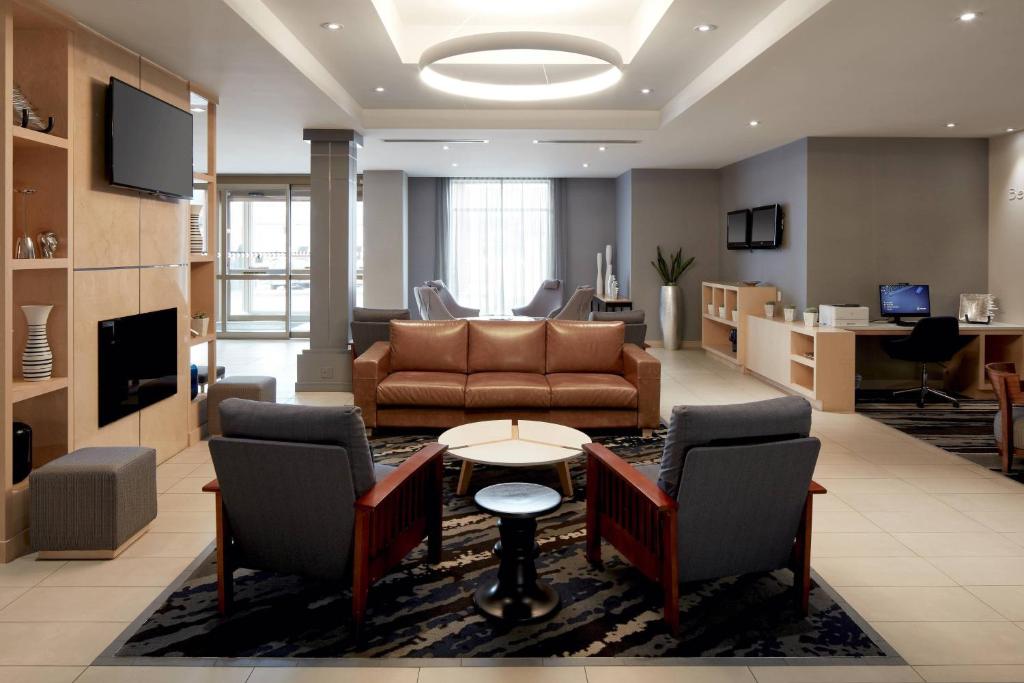 a living room with a couch and a table and chairs at Fairfield Inn & Suites by Marriott Montreal Airport in Dorval