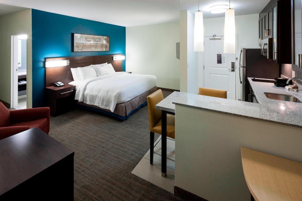 a hotel room with a bed and a kitchen at Residence Inn by Marriott Richmond Downtown in Richmond