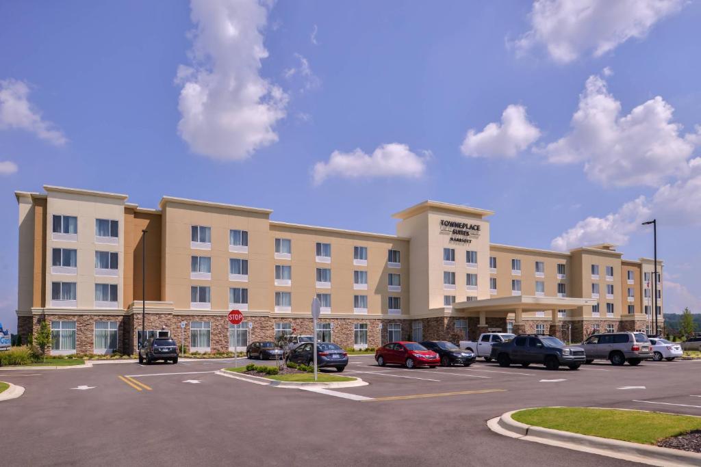 TownePlace Suites by Marriott Huntsville West/Redstone Gateway في هانتسفيل: مبنى كبير به سيارات تقف في موقف للسيارات