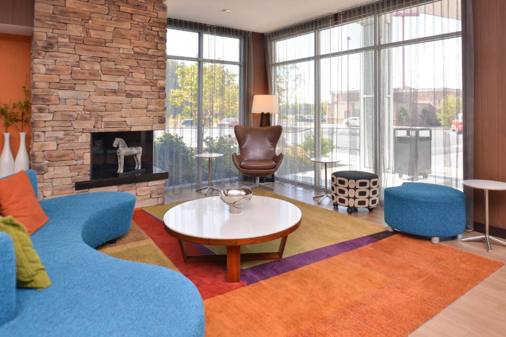 a living room with a couch and a table and a fireplace at Fairfield Inn and Suites by Marriott Calhoun in Calhoun