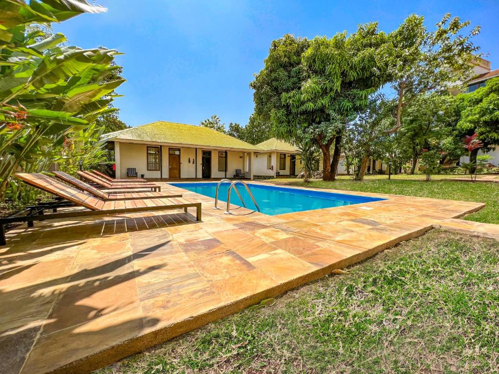 a backyard with a swimming pool and a house at Bristol Cottages Kilimanjaro in Moshi