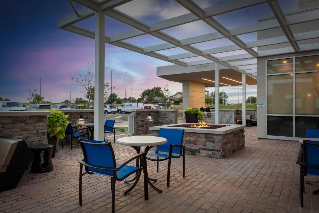 een patio met een tafel en stoelen en een vuurplaats bij SpringHill Suites Kansas City Airport in Kansas City