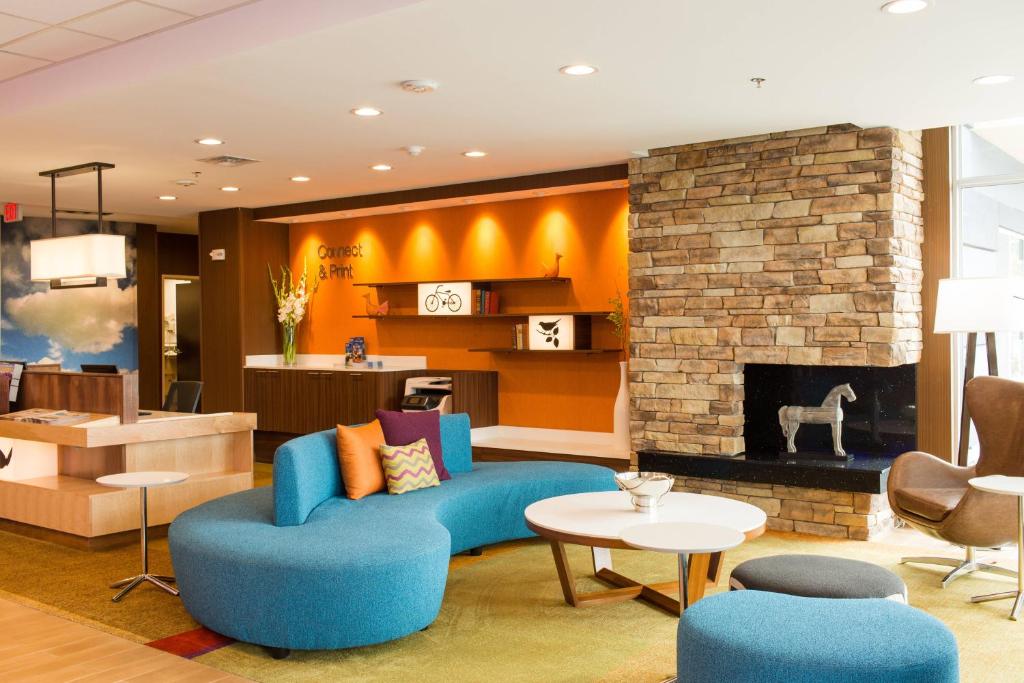a living room with a blue couch and a fireplace at Fairfield Inn & Suites by Marriott Sheridan in Sheridan