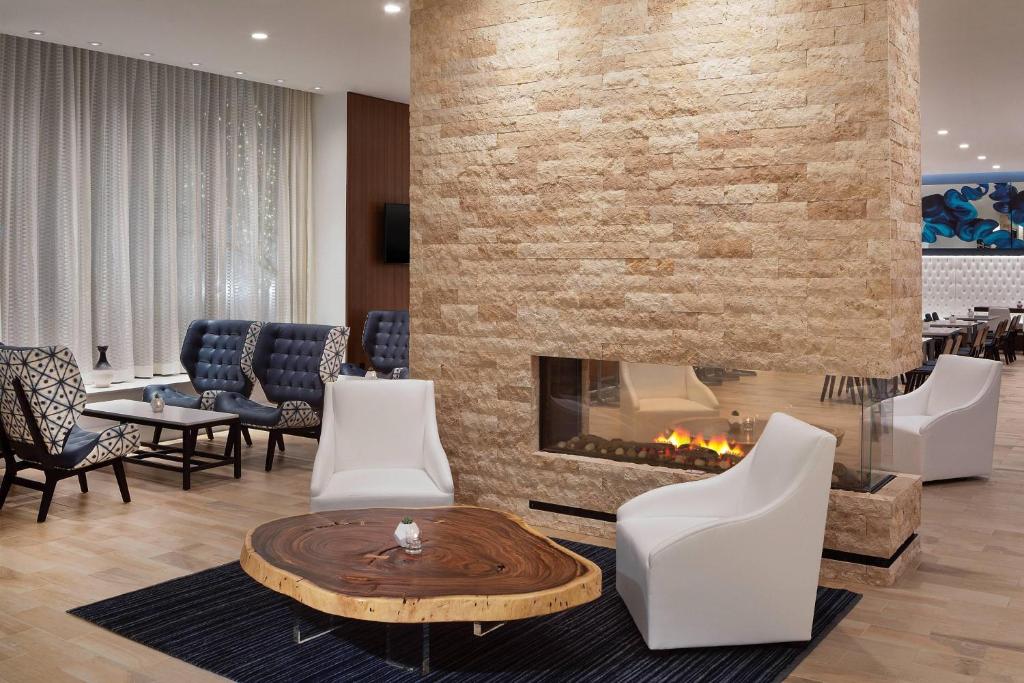 a lobby with a fireplace and chairs and a table at Residence Inn by Marriott Stamford Downtown in Stamford