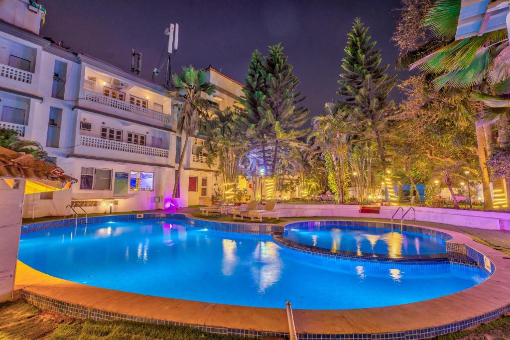 a large swimming pool in front of a building at night at The Boho, Vagator Beach Goa Near Thalassa in Anjuna
