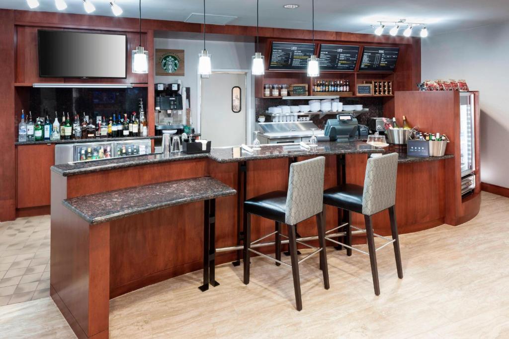 a bar in a restaurant with two bar stools at Courtyard by Marriott Waco in Waco